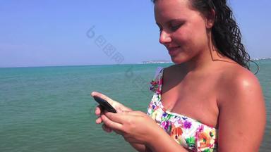 肖像有吸引力的少年女孩站<strong>夏</strong>天桑迪海滩假期持有智能手机设备冲浪网络假期蓝色的<strong>天空</strong>人旅行技术稳定摄像头呃<strong>镜头</strong>